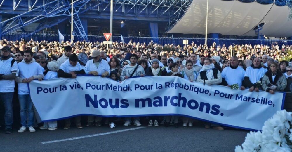 Foule portant une banderole lors de la marche blanche pour Mehdi Kessaci à Marseille .